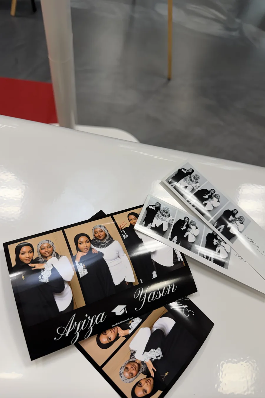 Photo booth prints resting on the booth.