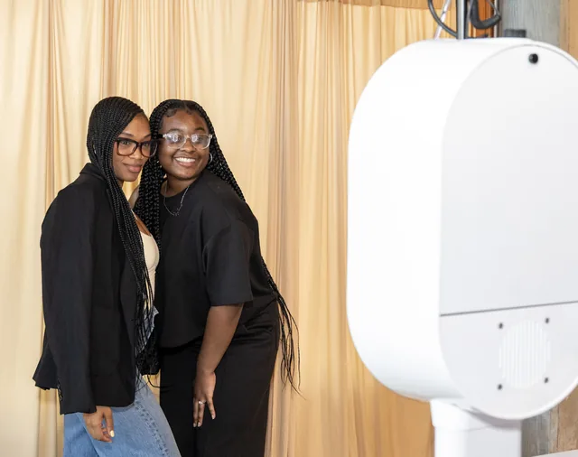 Guests posing beside the booth at a Portland event.